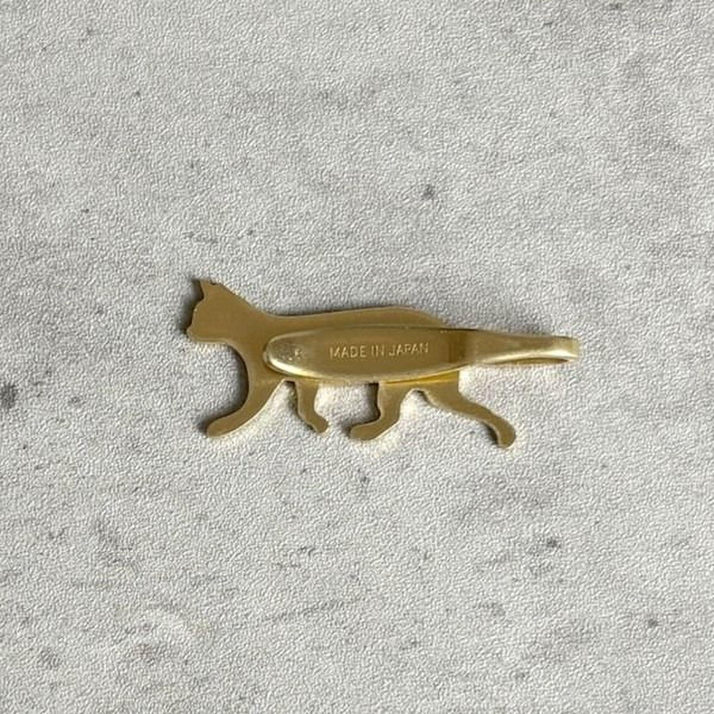 A golden cat-shaped object is shown against a textured gray background.
