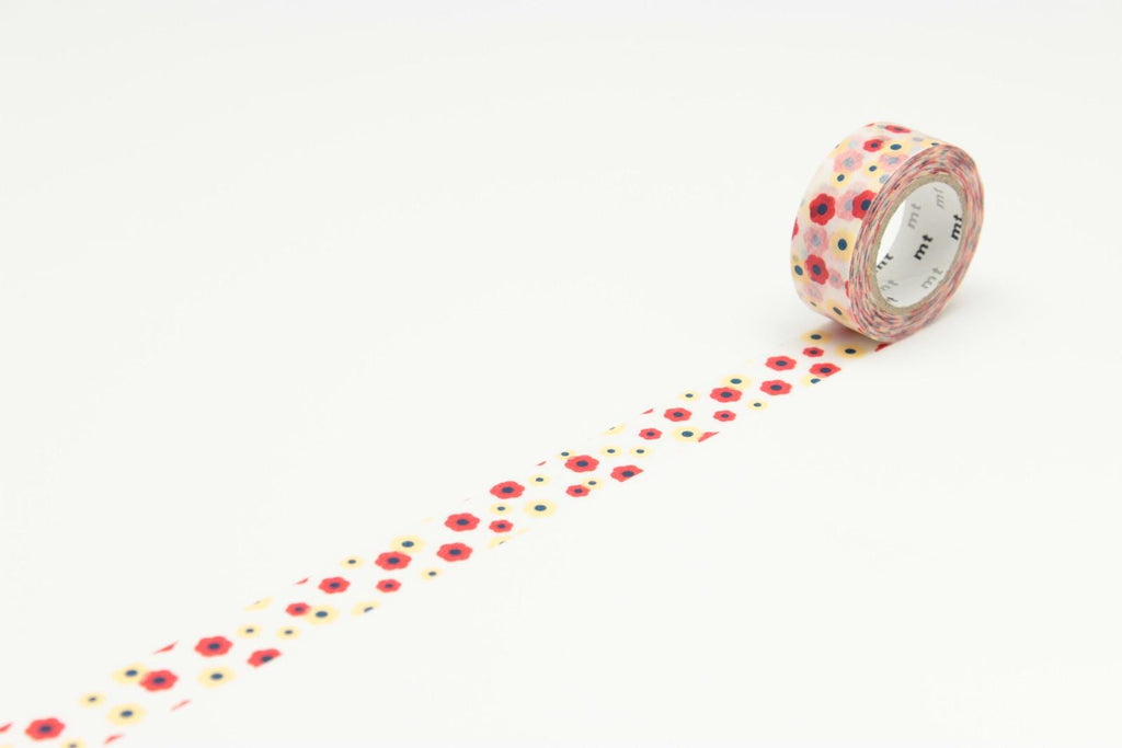 A roll of patterned tape with a floral design is placed on a white surface, with the tape extending across the image.