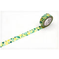 A roll of green and yellow patterned tape is lying on a white surface, with the tape partially unwinding and revealing a pattern of green and yellow shapes.