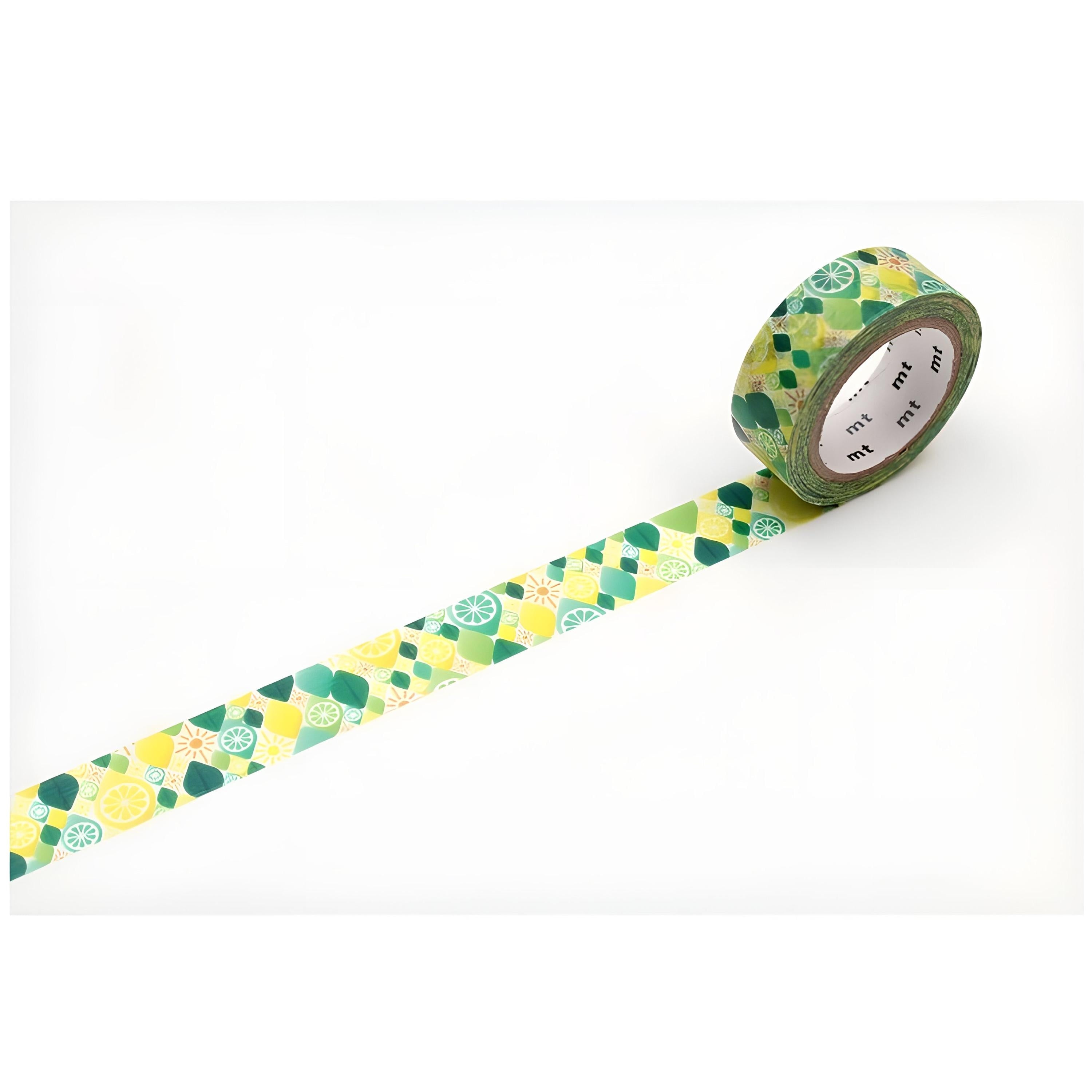 A roll of green and yellow patterned tape is lying on a white surface, with the tape partially unwinding and revealing a pattern of green and yellow shapes.