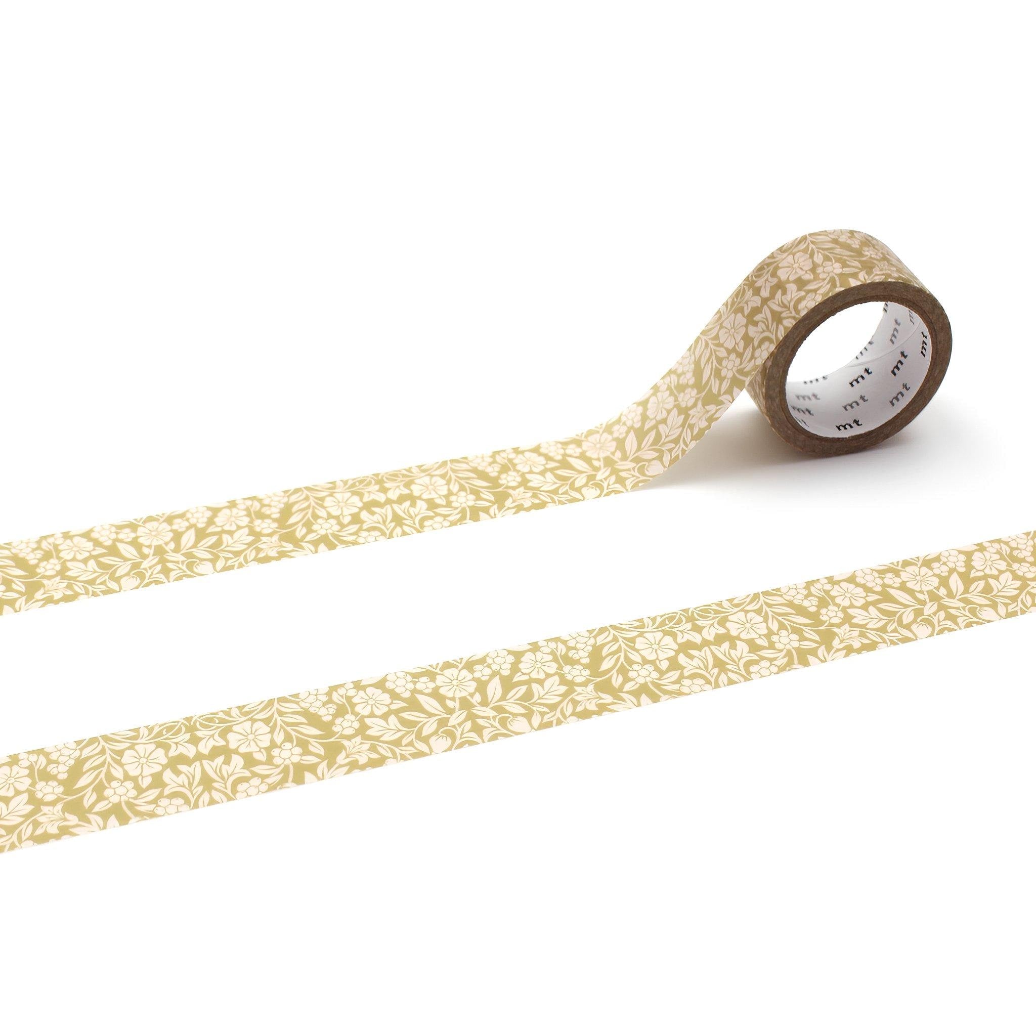 a roll of gold-colored floral patterned tape lying on a white background.