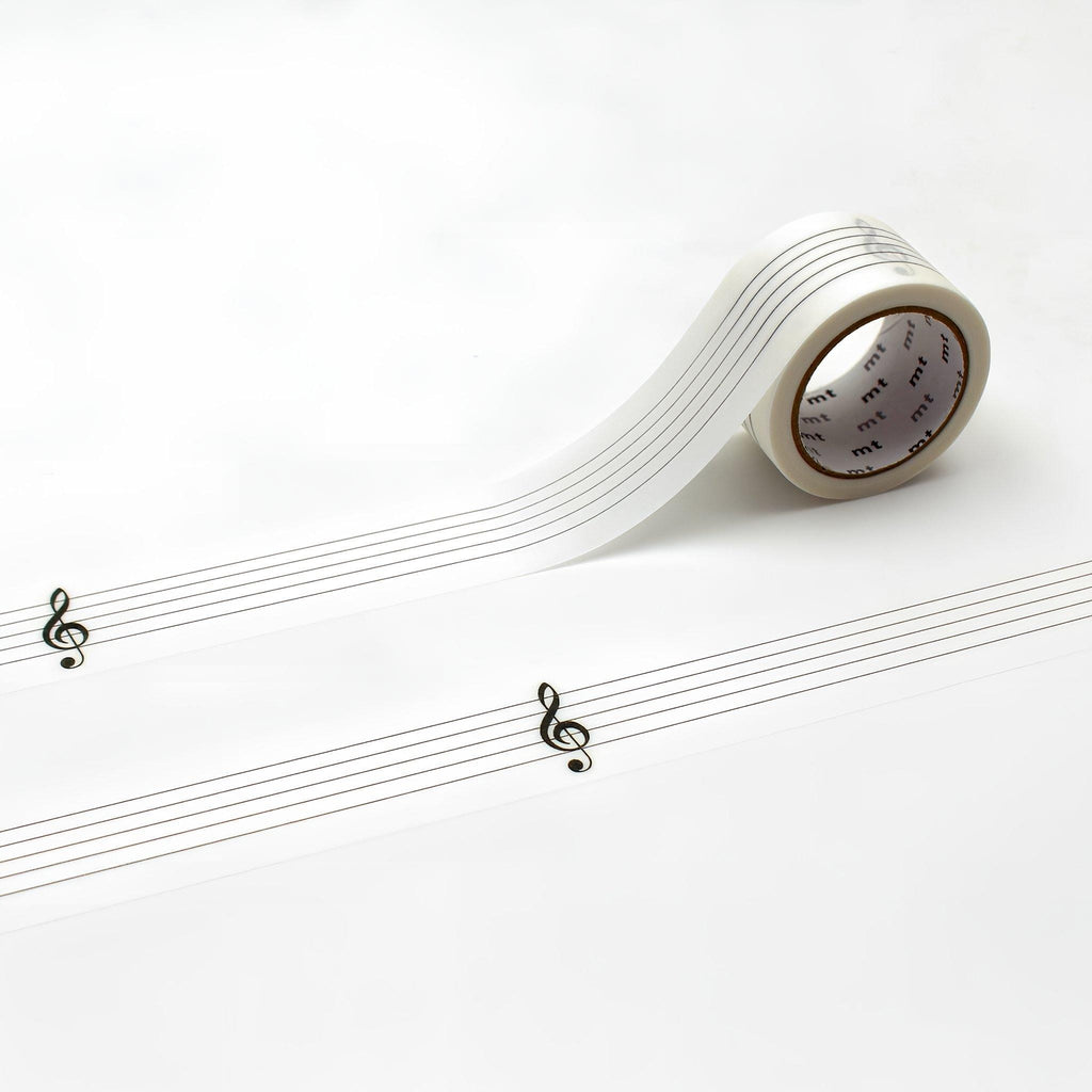 a roll of clear tape with musical notes printed on it, placed on a white surface.