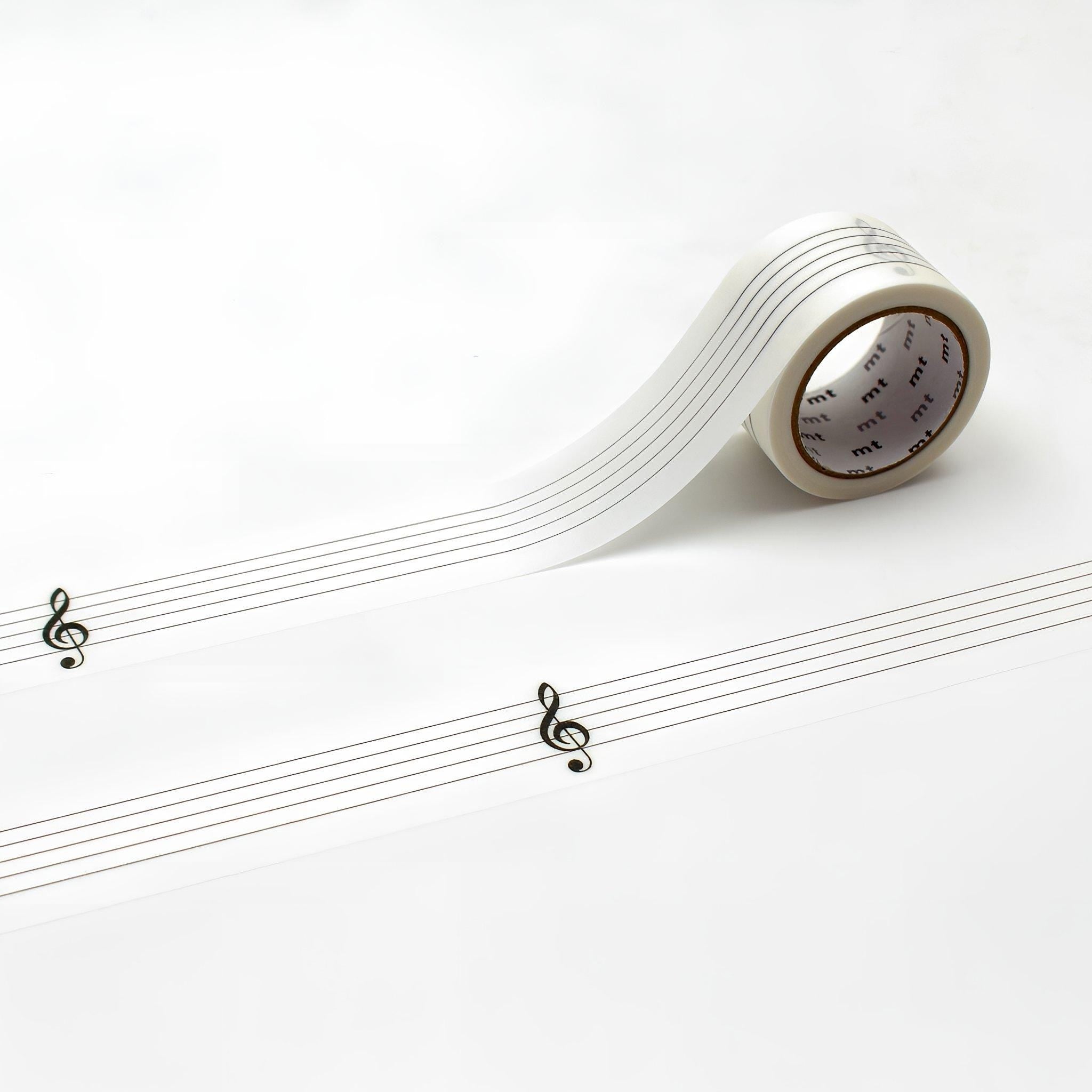 a roll of clear tape with musical notes printed on it, placed on a white surface.