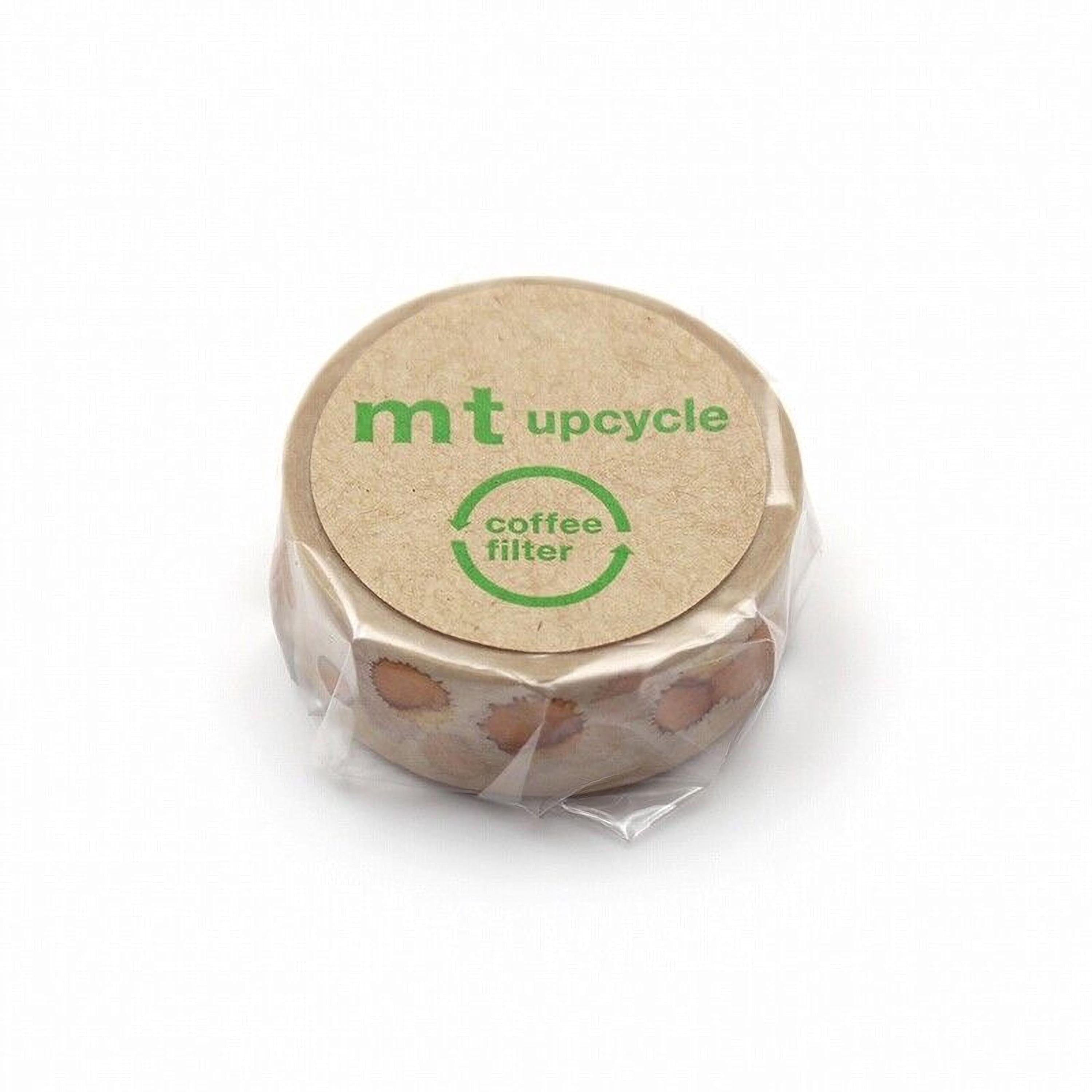 A circular object with a brown cover, featuring the text "mt upcycle" and "coffee filter" printed on it.