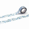 A roll of patterned tape with a repeating design of cats and leaves on it, lying on a white surface.