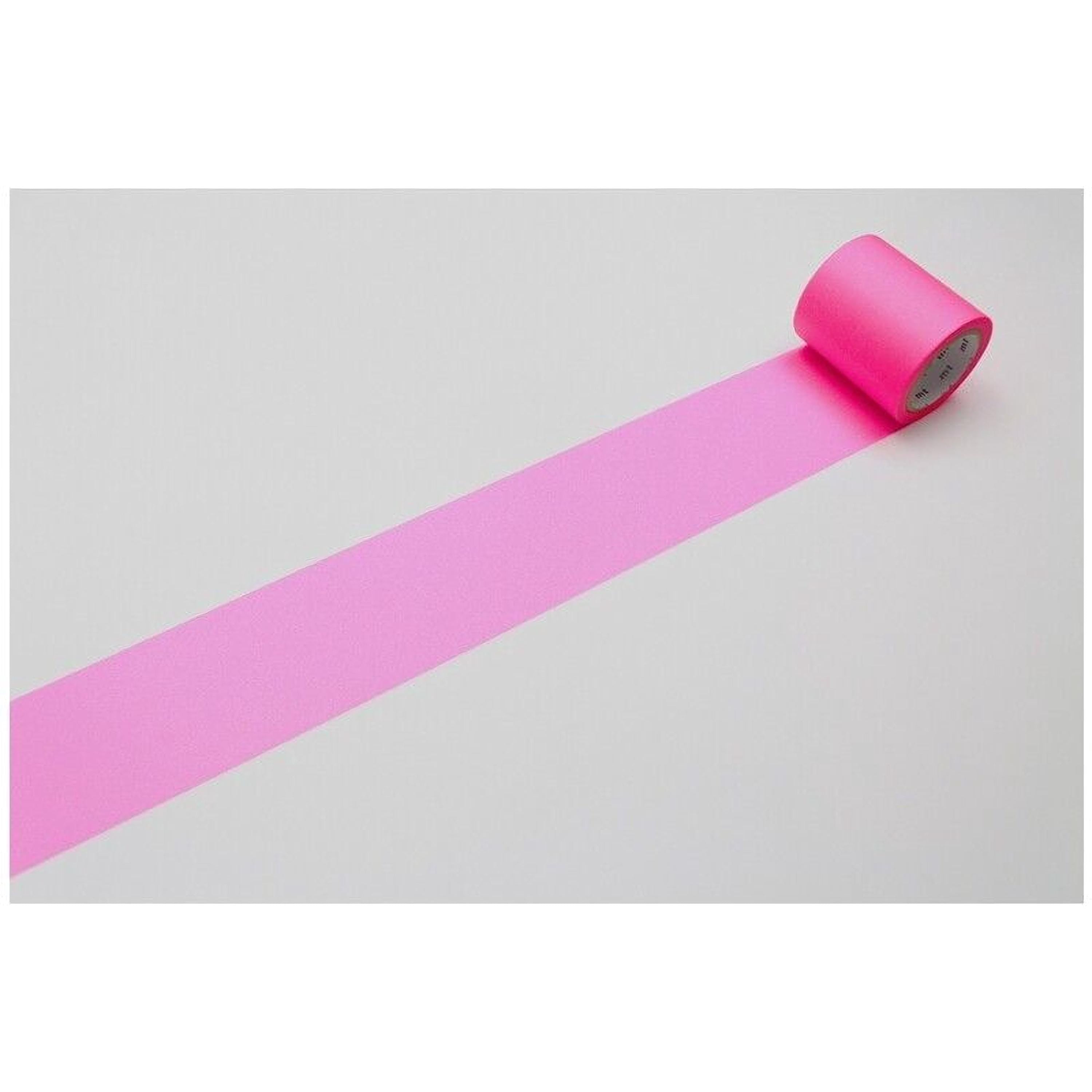 A roll of pink tape is lying on a white surface, with a single pink stripe visible on the tape.