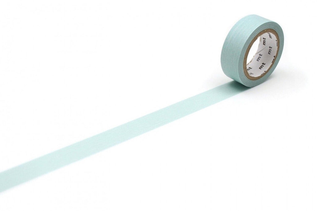 A roll of light blue tape with a white clock face on it is placed on a white surface, with a long light blue line extending from the tape.