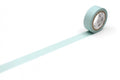 A roll of light blue tape with a white clock face on it is placed on a white surface, with a long light blue line extending from the tape.