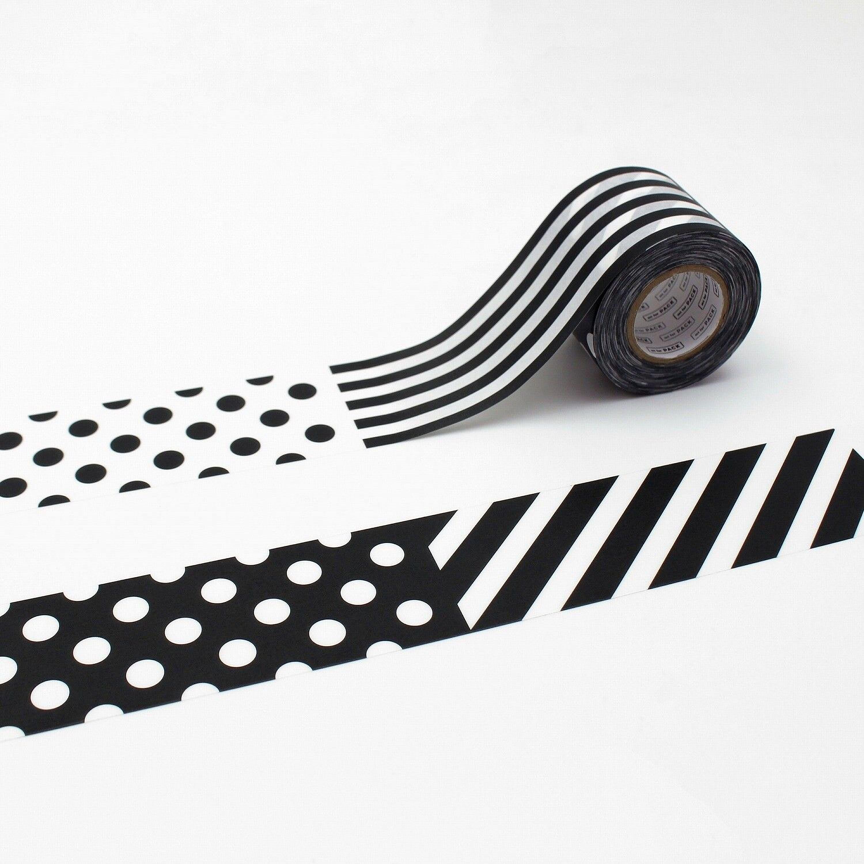 a roll of black and white striped tape with a pattern of polka dots and diagonal stripes.