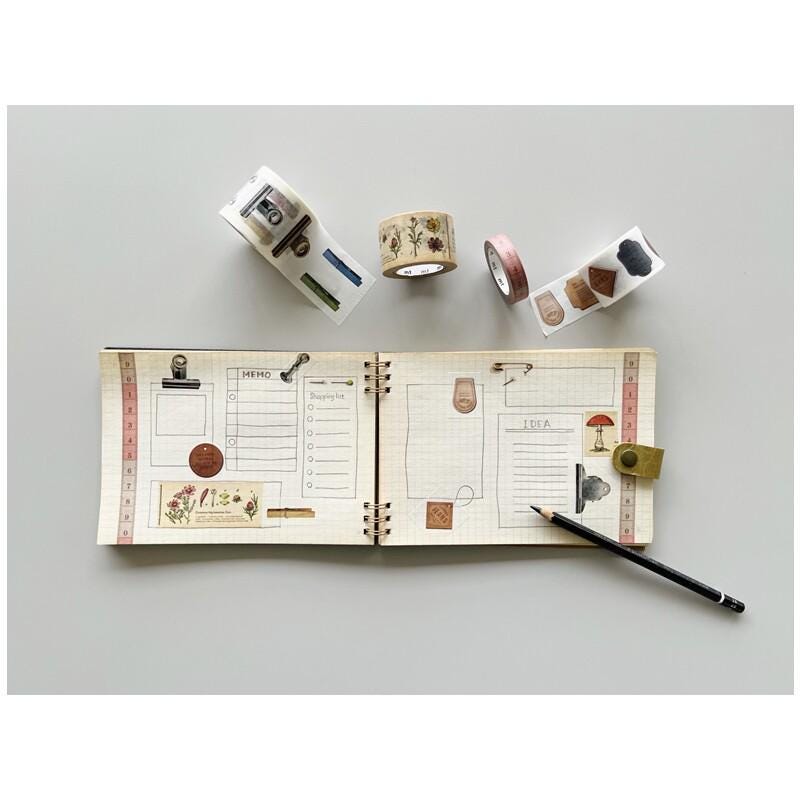 an open notebook with various stickers, a pencil, and a ruler on a white background.