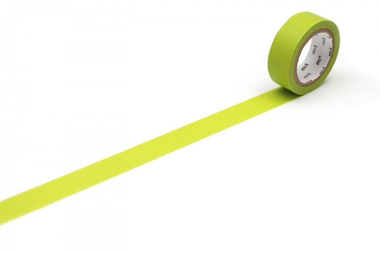 A roll of green tape with a white pattern on it is lying on a white surface, with a long yellow line extending from the tape.