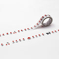 a roll of white tape with red and black designs, including a cat, flowers, and a house, arranged in a repeating pattern.