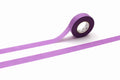 A roll of purple masking tape is lying on its side on a white background.