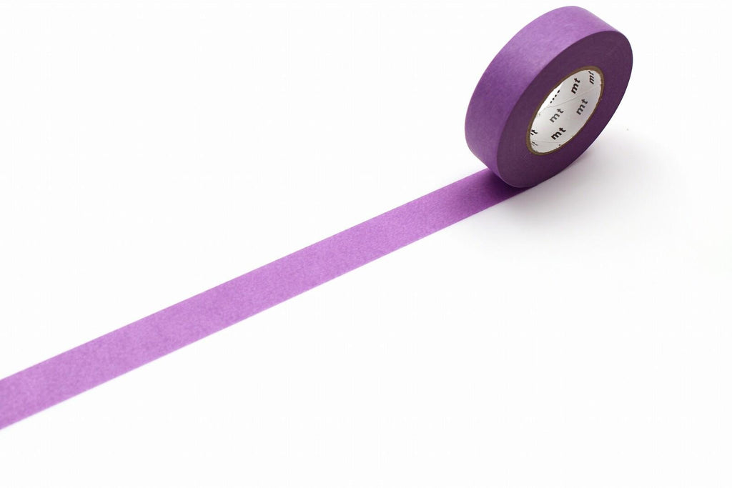 A roll of purple masking tape is lying on a white surface, with a single purple strip extending from the tape.