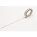 A roll of colorful fish-shaped washi tape is lying on a white surface, with a pattern of fish visible on the tape.