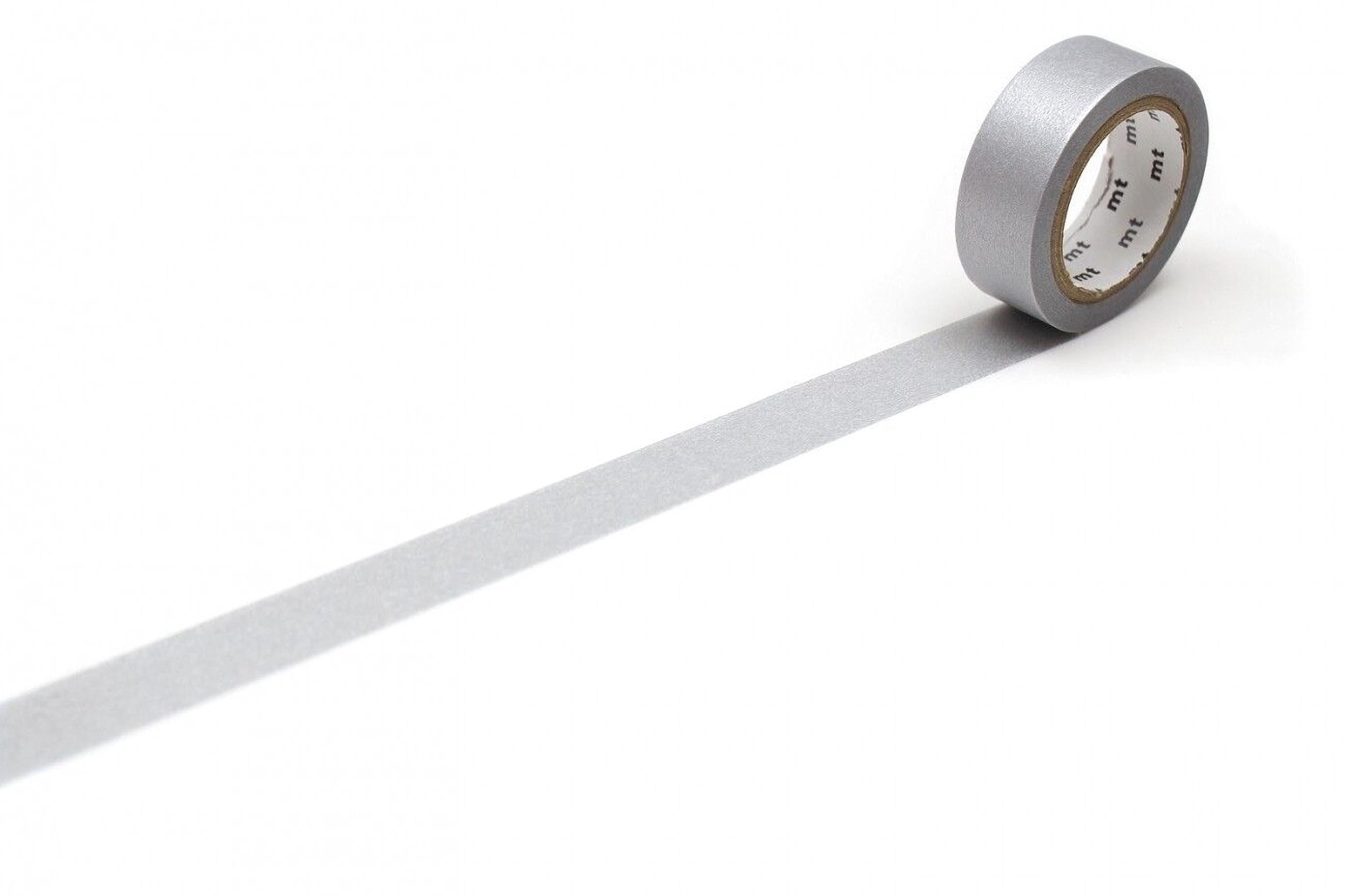 A roll of silver-colored tape is lying on a white surface, with a single strip of tape extending from the end of the roll.