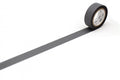 A roll of black tape with a white center is placed on a white surface, lying on its side.