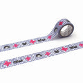 a roll of patterned tape with a checkered grid design and pink and black cat-like figures on it.