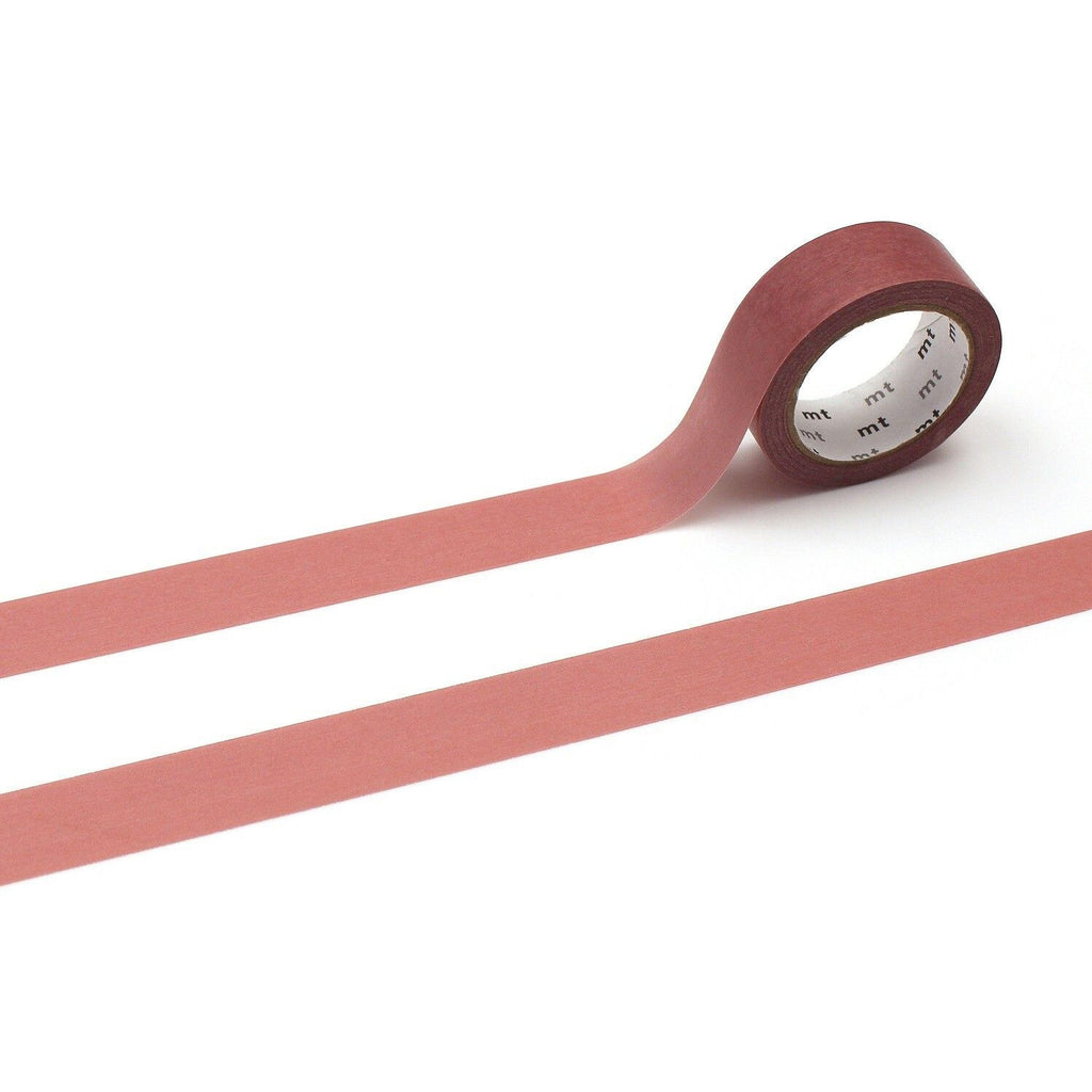 A roll of red masking tape with a white label is placed on a white surface, with two horizontal red strips extending from the tape.