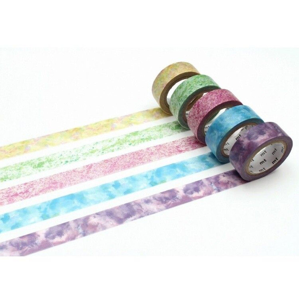 A collection of six colorful, patterned, and textured washi tape rolls arranged in a row on a white background.