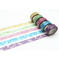 A collection of six colorful, patterned, and textured washi tape rolls arranged in a row on a white background.