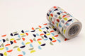 A roll of colorful patterned tape is lying on a white surface, with a repeating pattern of overlapping circles in various colors.