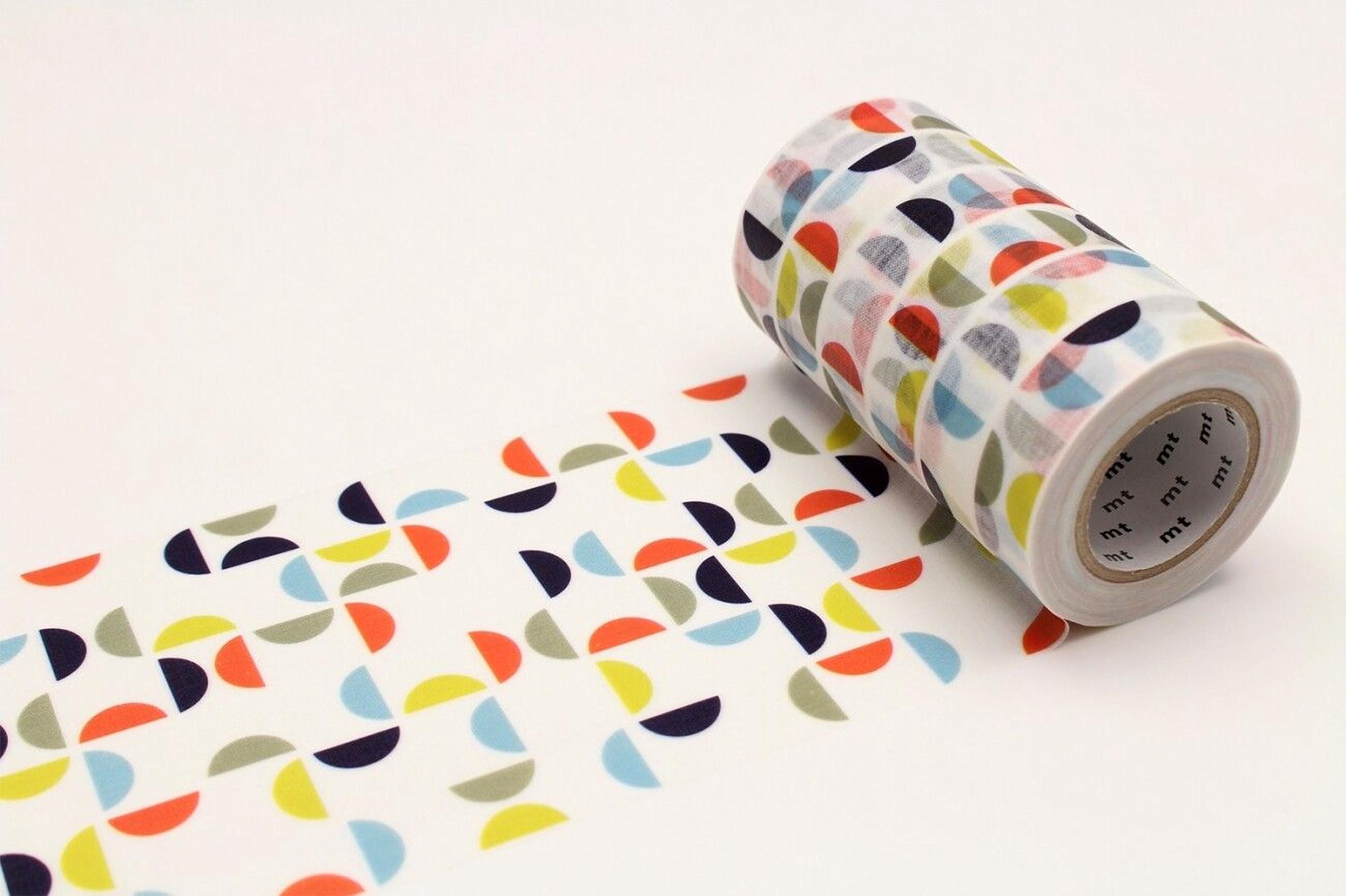 A roll of colorful patterned tape is lying on a white surface, with a repeating pattern of overlapping circles in various colors.