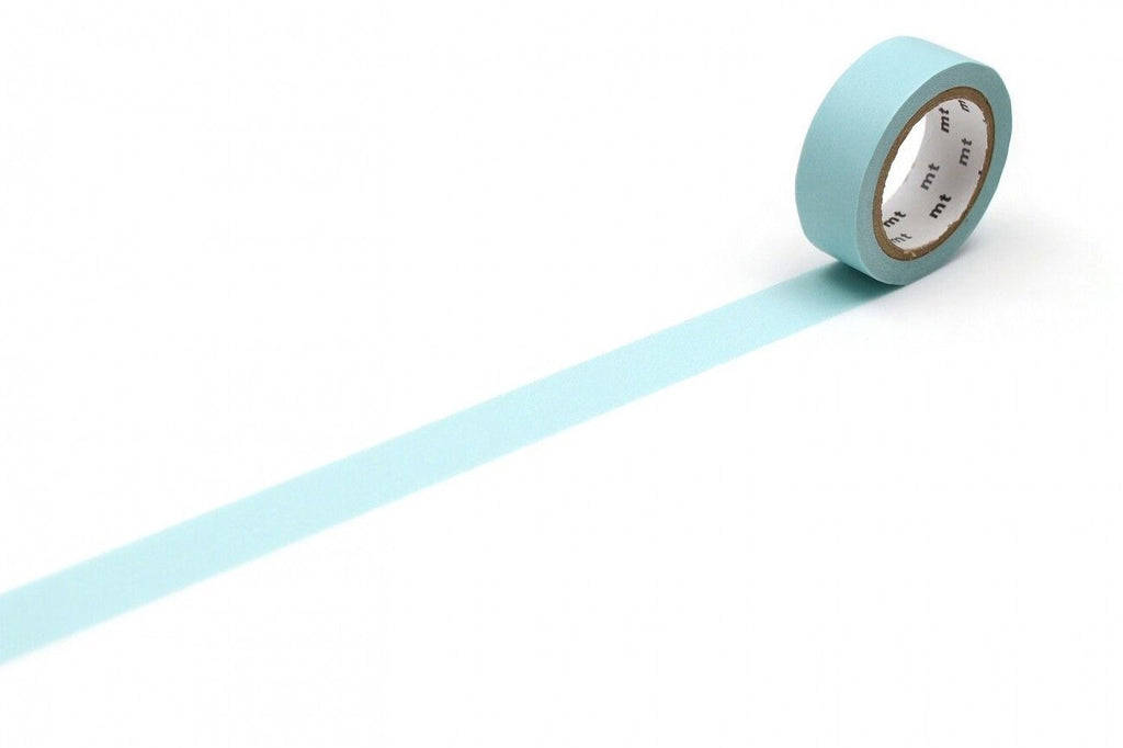 A roll of light blue tape with a white center is lying on a white surface, with a long blue line extending from the tape.