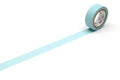 A roll of light blue tape with a white center is lying on a white surface, with a long blue line extending from the tape.