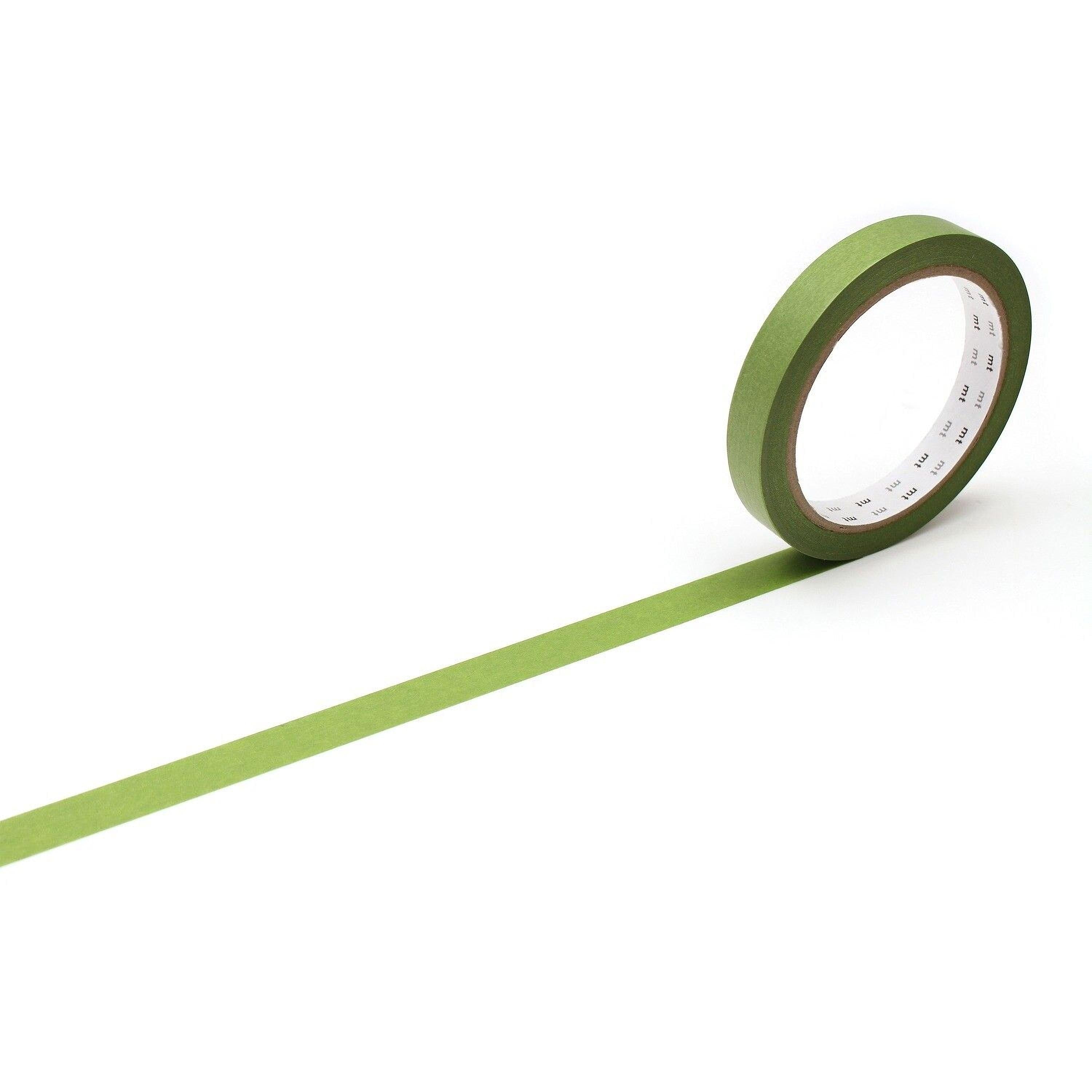 A roll of green tape with a white center is lying on a white surface, extending horizontally across the image.