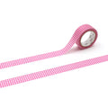 A roll of pink and white checkered tape is lying on a white surface, with the tape partially unwinding and extending across the image.