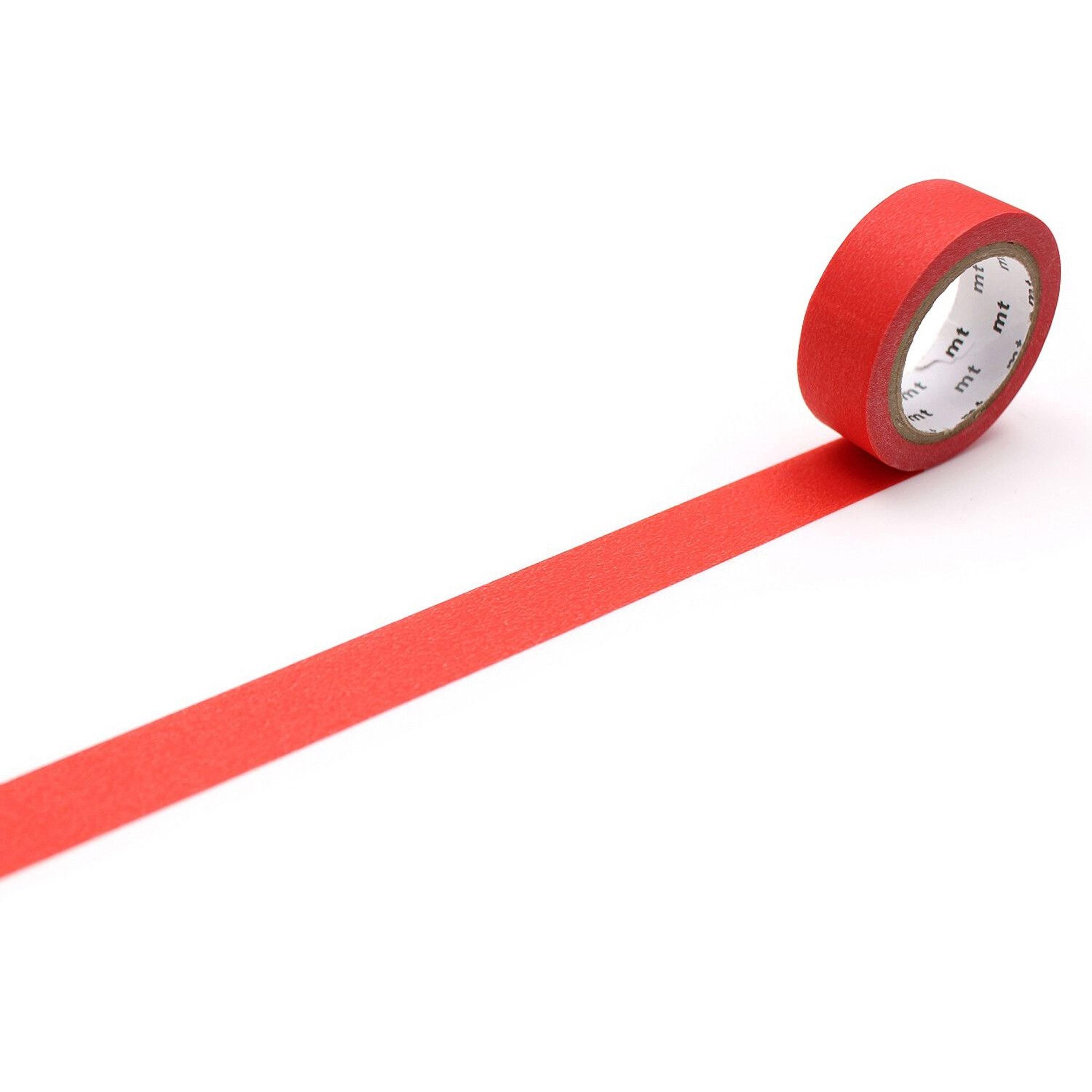 A roll of red tape is lying on a white surface, with a single red line extending from the tape.