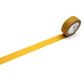 A roll of yellow tape with a white label is lying on a white surface, with a yellow line extending from the tape.