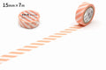a roll of tape with a striped pattern, and there is another roll of tape lying on the floor next to it.