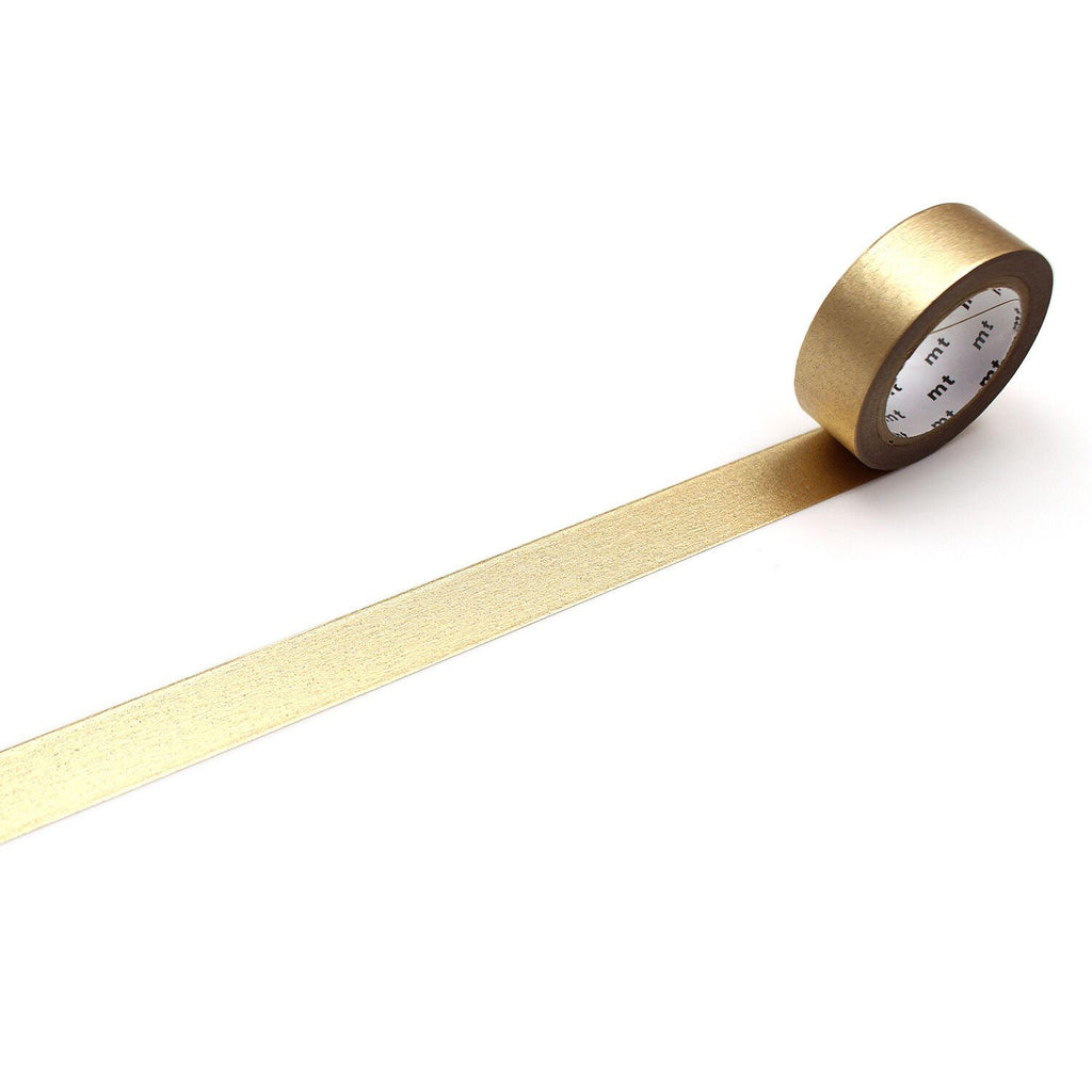 A roll of gold metallic tape is lying on a white surface, with a gold stripe running along it.