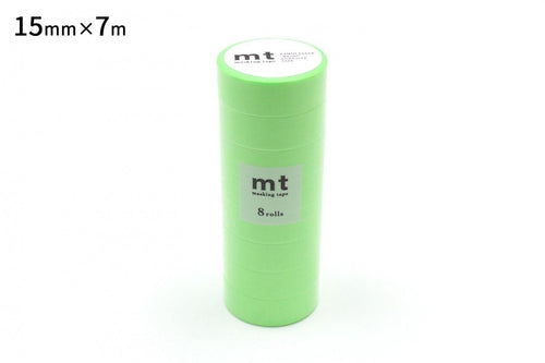 A stack of green cylindrical objects, likely some kind of packaging or container, with a label on the top.