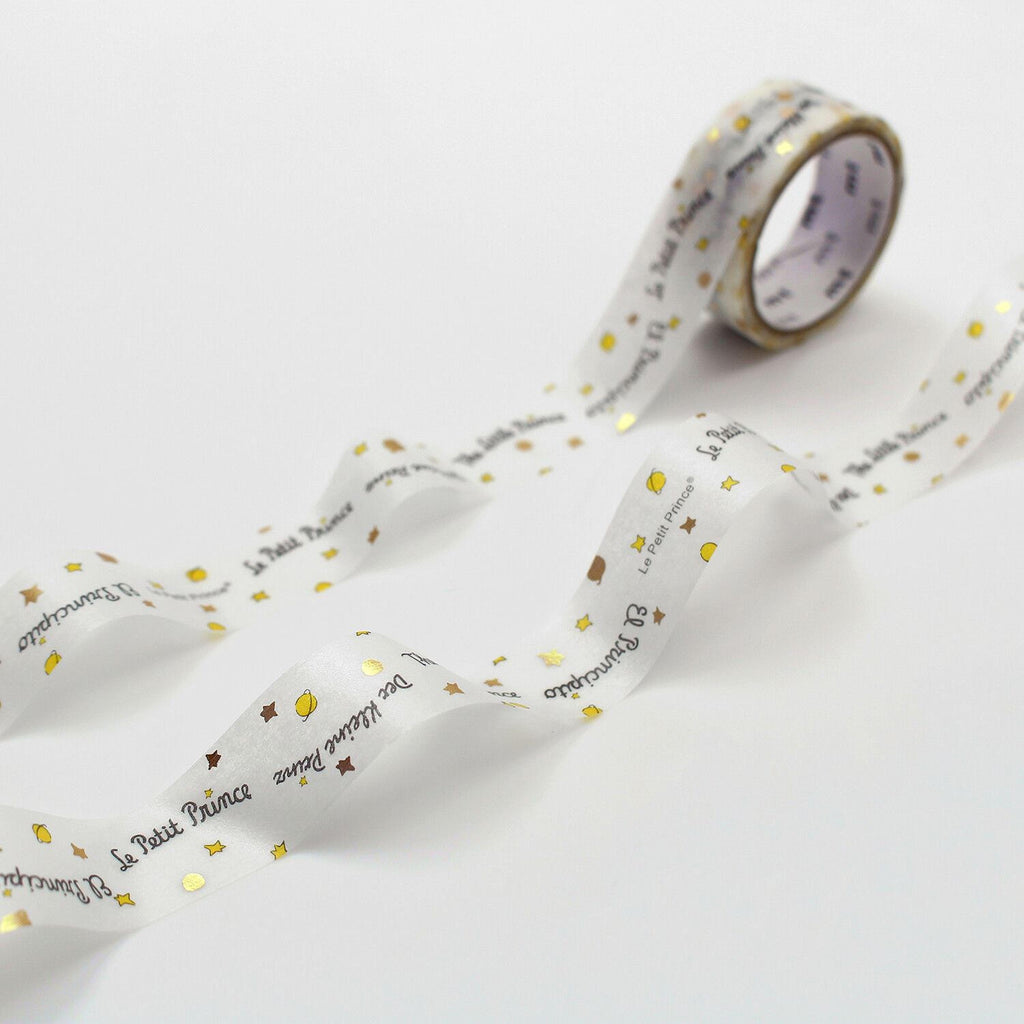a roll of white tape with gold stars and text printed on it, lying on a white surface.