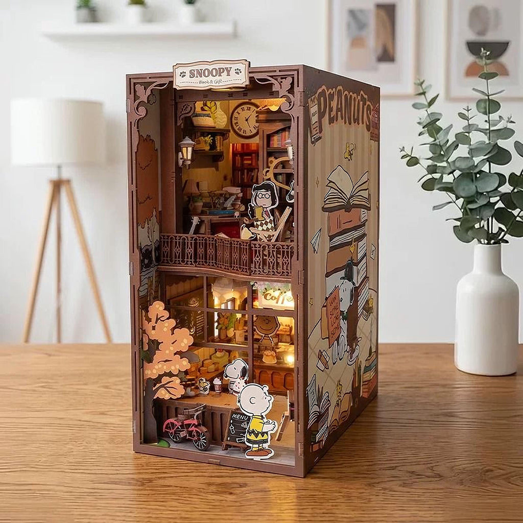 A miniature Peanuts-themed dollhouse with a cozy interior, featuring a clock, books, and other Peanuts characters.