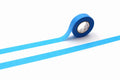 A roll of blue masking tape is lying on a white surface, with a blue line running across the image.