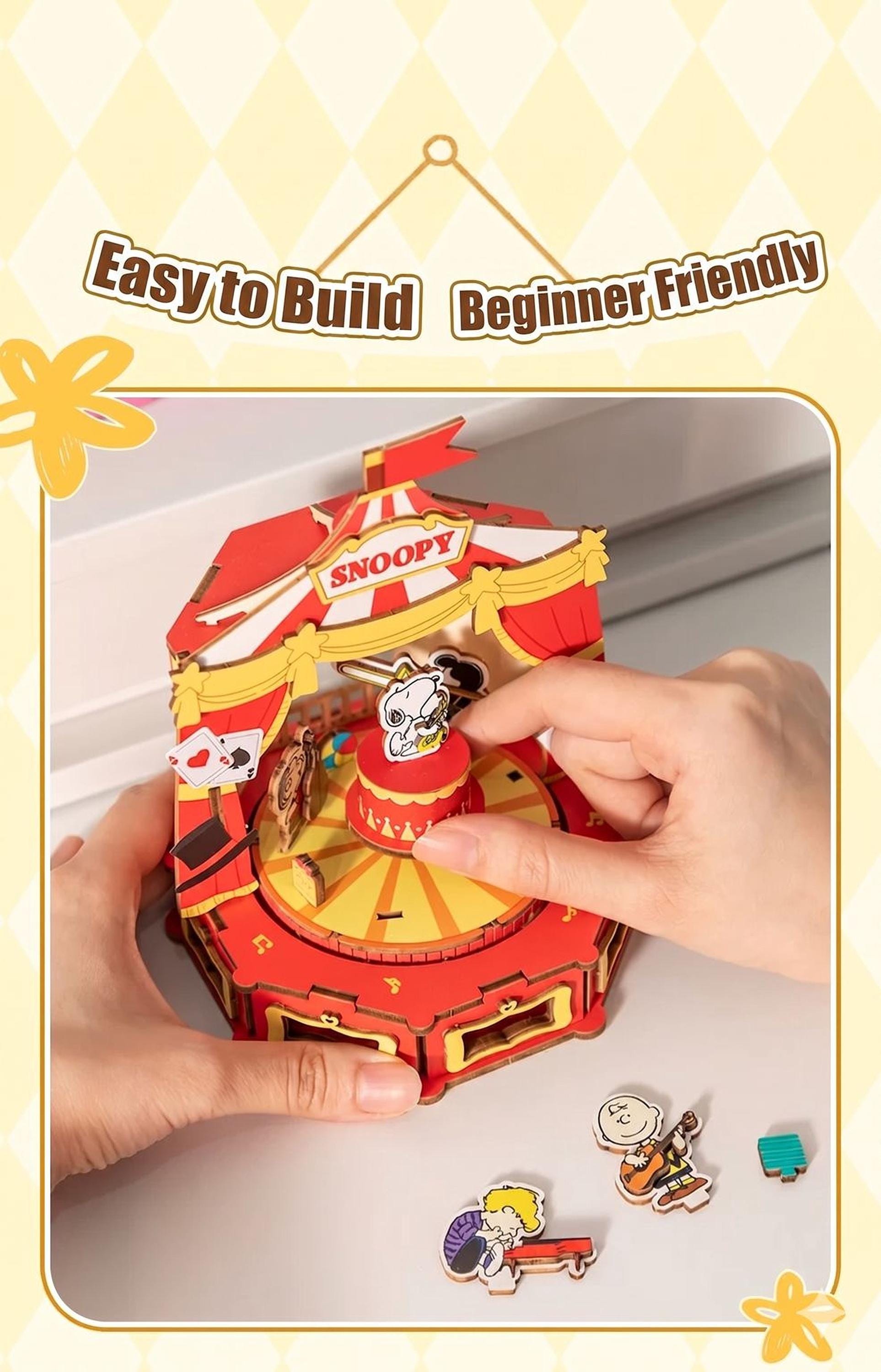 A person is interacting with a colorful, paper-based toy resembling a carnival ride, with the words "Easy to Build Beginner Friendly" displayed above the toy.