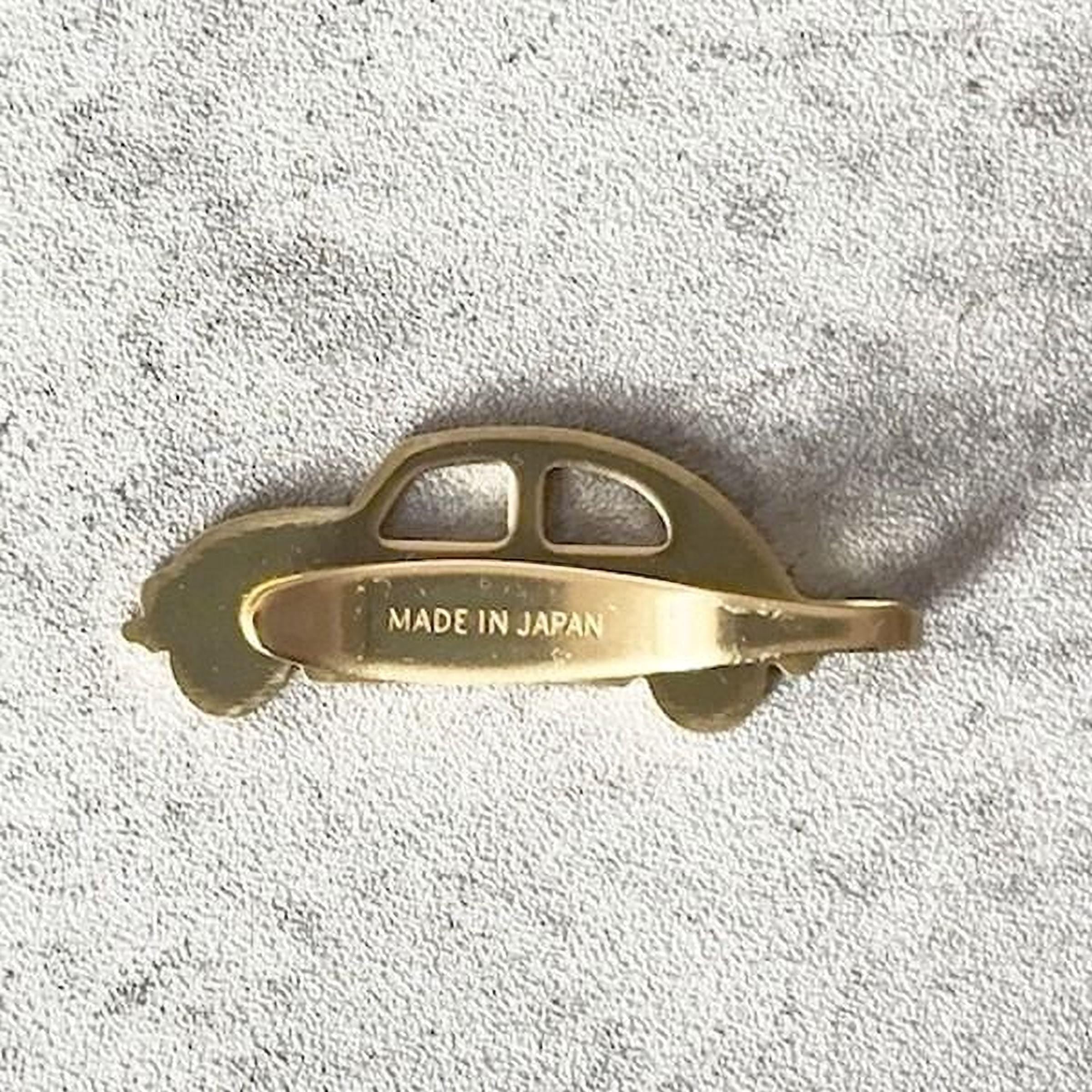 A gold-colored car-shaped object with the text "MADE IN JAPAN" printed on it.