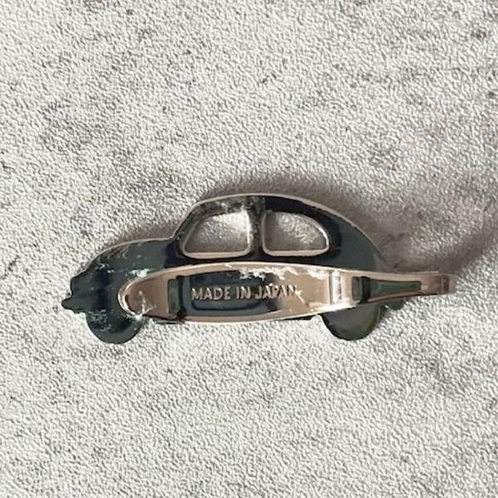 A silver-colored metal object resembling a car or vehicle, with the text "MADE IN JAPAN" printed on it.