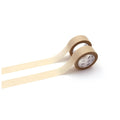 Two rolls of beige paper tape are lying on a white background.