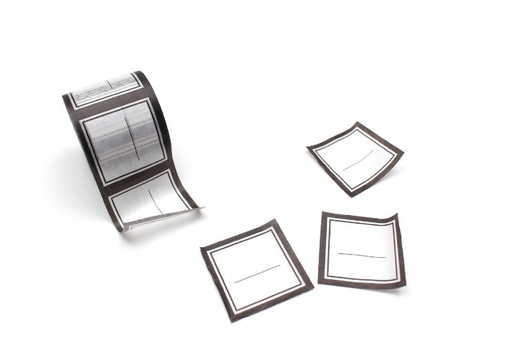 a roll of paper with a black and white design, along with three additional paper pieces with similar black and white designs.