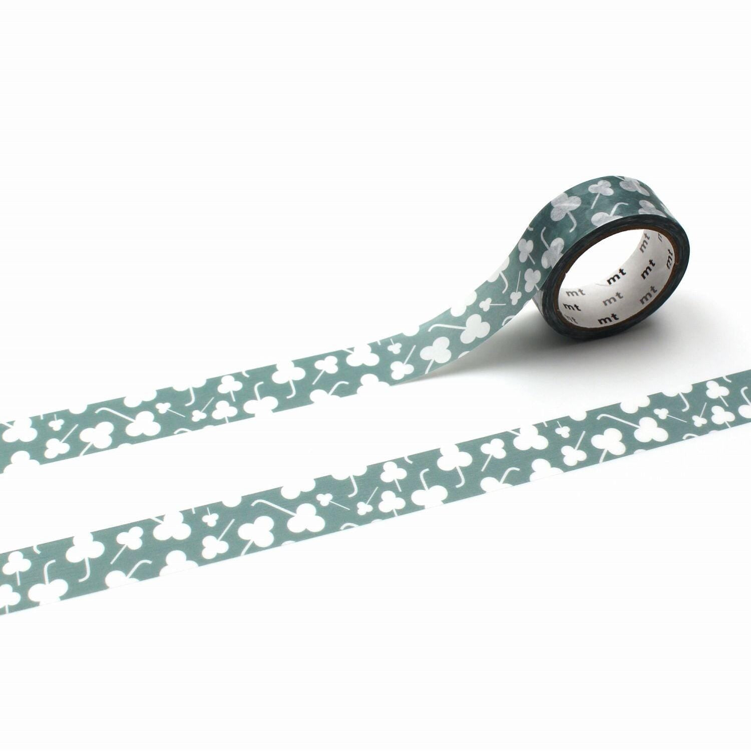 A roll of green and white patterned tape with a repeating design of white flowers or leaves on a white background.