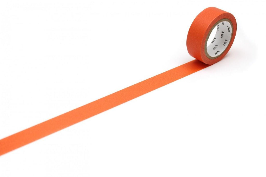 a roll of orange tape with a clock face on it, placed on a white surface.