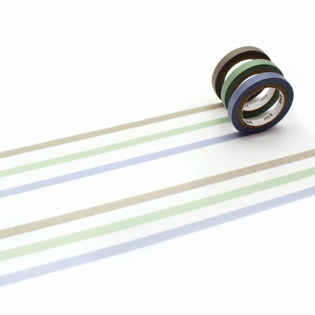 A roll of colorful tape is lying on a white surface, with a series of horizontal stripes in various colors, including blue, green, and brown.