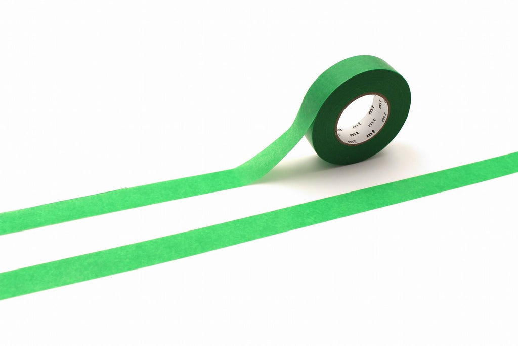 A roll of green tape is lying on a white surface, with a green line extending from the tape.