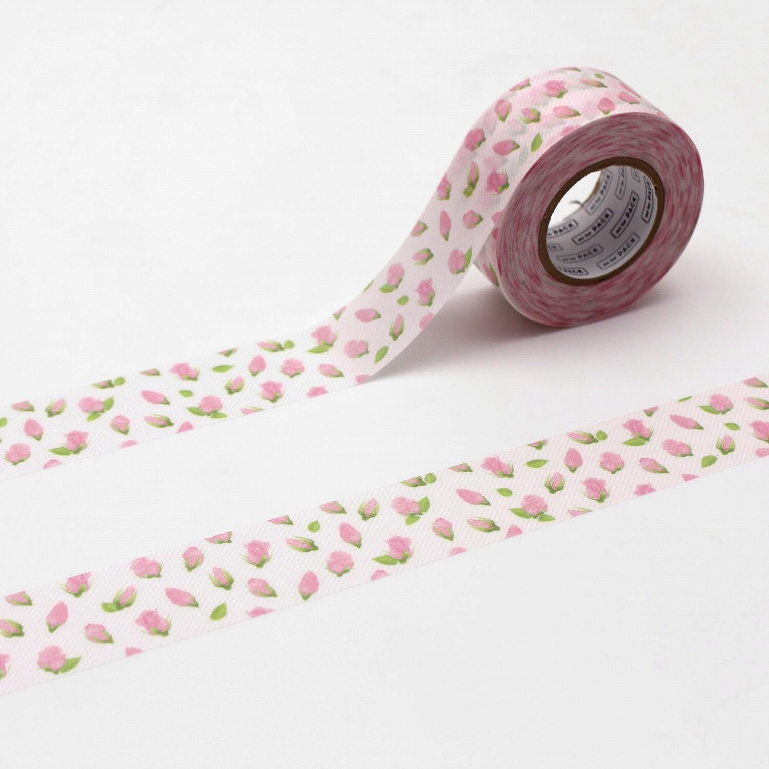 A roll of pink and white patterned tape with a repeating rose design is shown against a white background.
