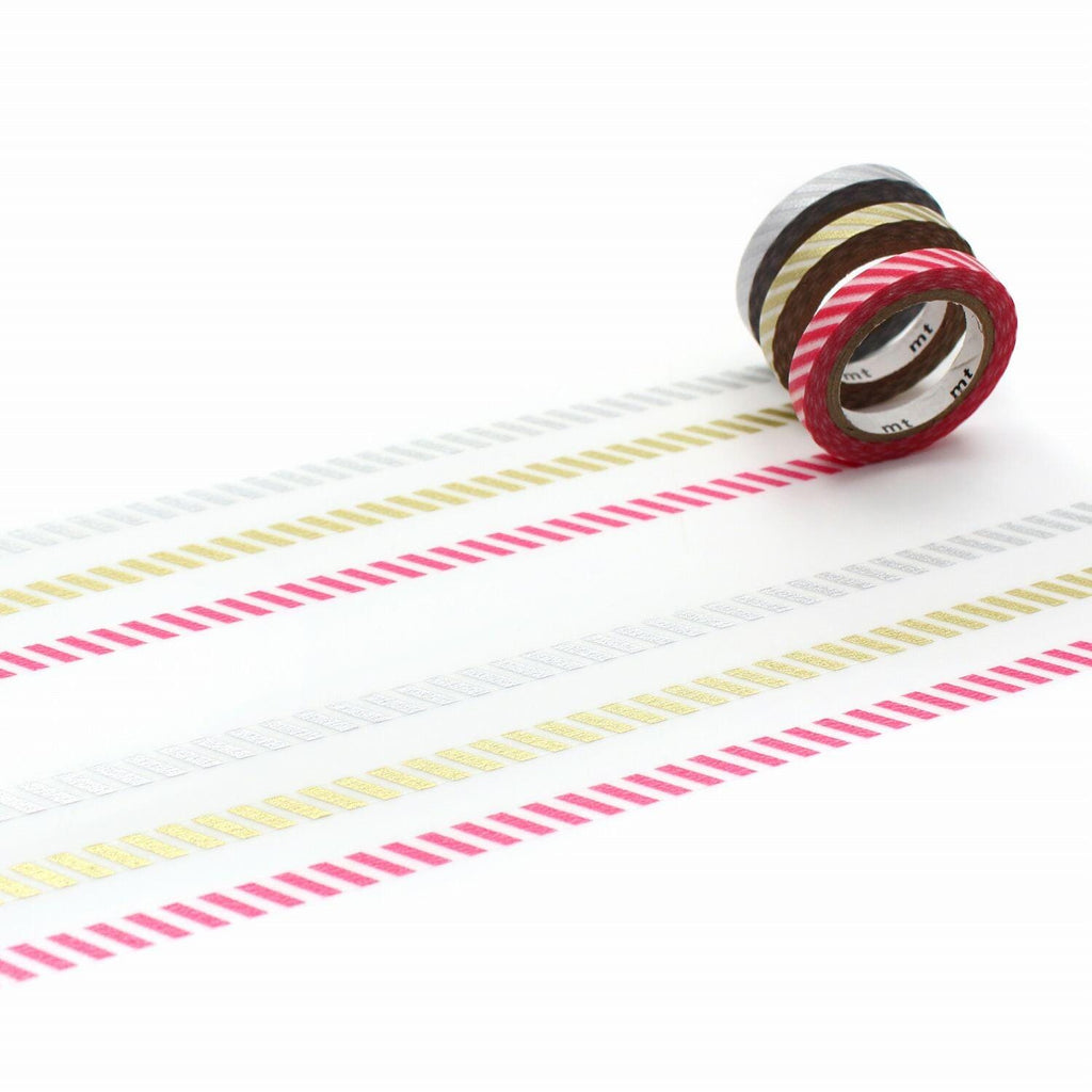A roll of colorful patterned tape is placed on a white surface, with a few other rolls of tape visible in the background.